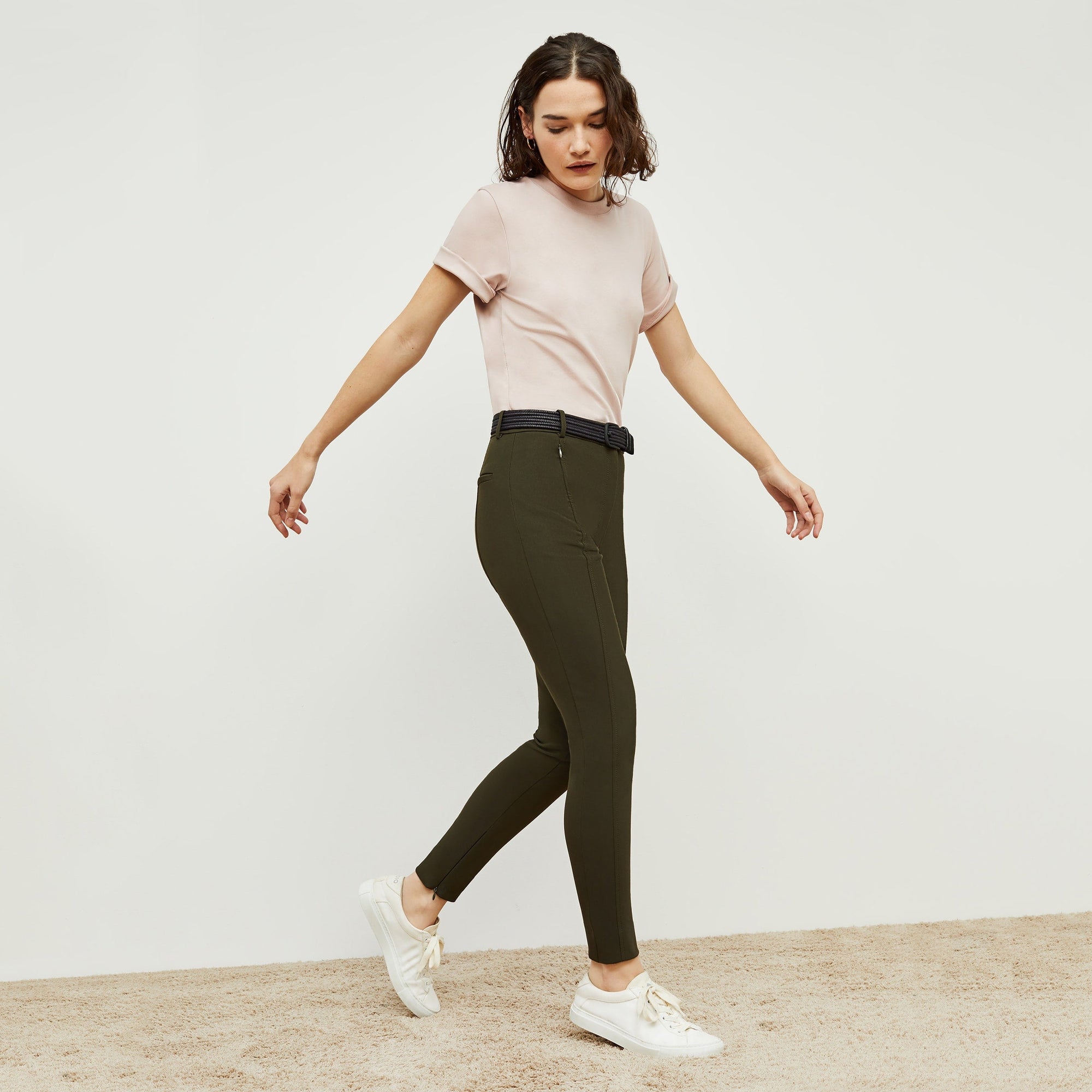 Side image of a woman standing wearing the curie pant in dark olive | Exclude