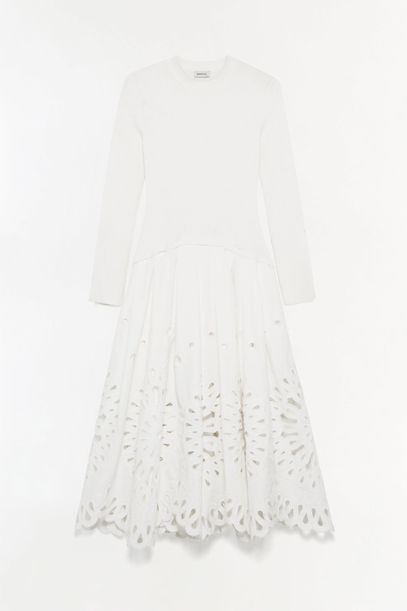 White knit midi dress with long sleeves and cutout embroidered detailing on the skirt.