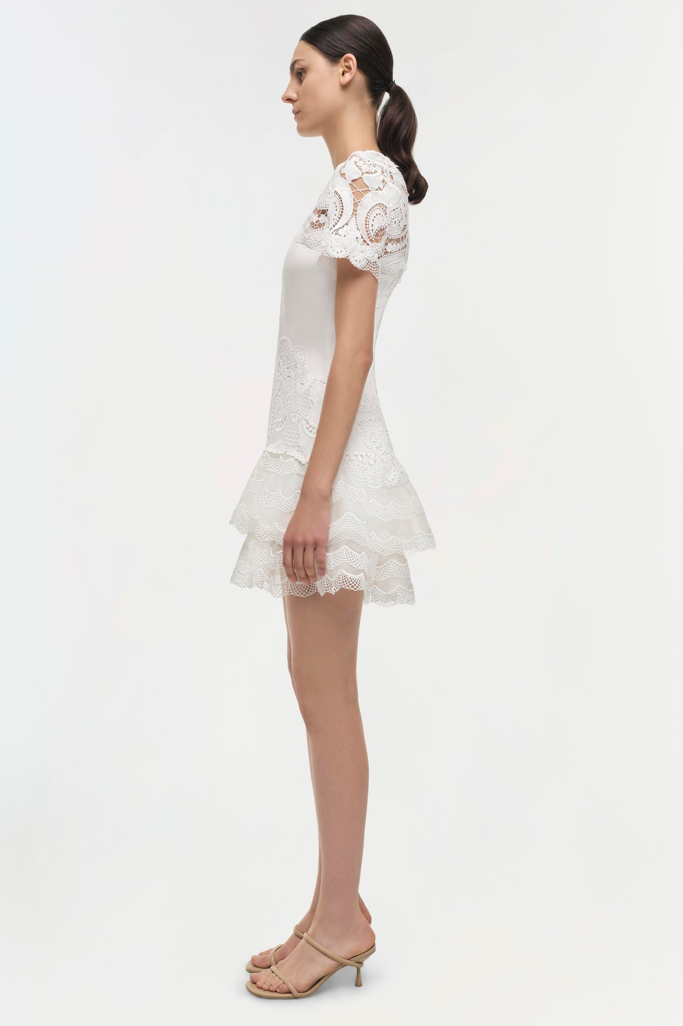 White lace dress with short sleeves, tiered skirt, and paisley pattern throughout.