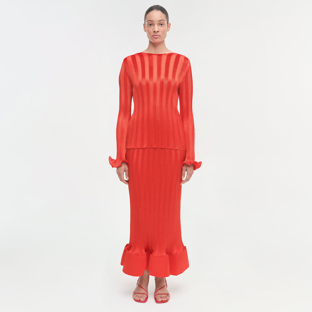 Red ribbed long-sleeve top with ruffled cuffs and hem detail.