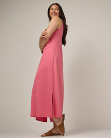 Model wearing Audrey TENCEL™ Maxi Dress in Geranium Heather, a soft heathered medium pink color. Audrey TENCEL™ Maxi Dress is a merino wool sleeveless, scoop neck, maxi shift dress with pockets available in sizes XS-3X.