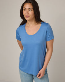 Model wearing Stella Signature Scoop Neck Tee in Blue Jay, a saturated sky blue color. Stella Signature Scoop Neck Tee is a merino wool short sleeve, scoop neck, relaxed fit tee available in sizes XS-3X.