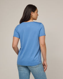 Model wearing Stella Signature Scoop Neck Tee in Blue Jay, a saturated sky blue color. Stella Signature Scoop Neck Tee is a merino wool short sleeve, scoop neck, relaxed fit tee available in sizes XS-3X.