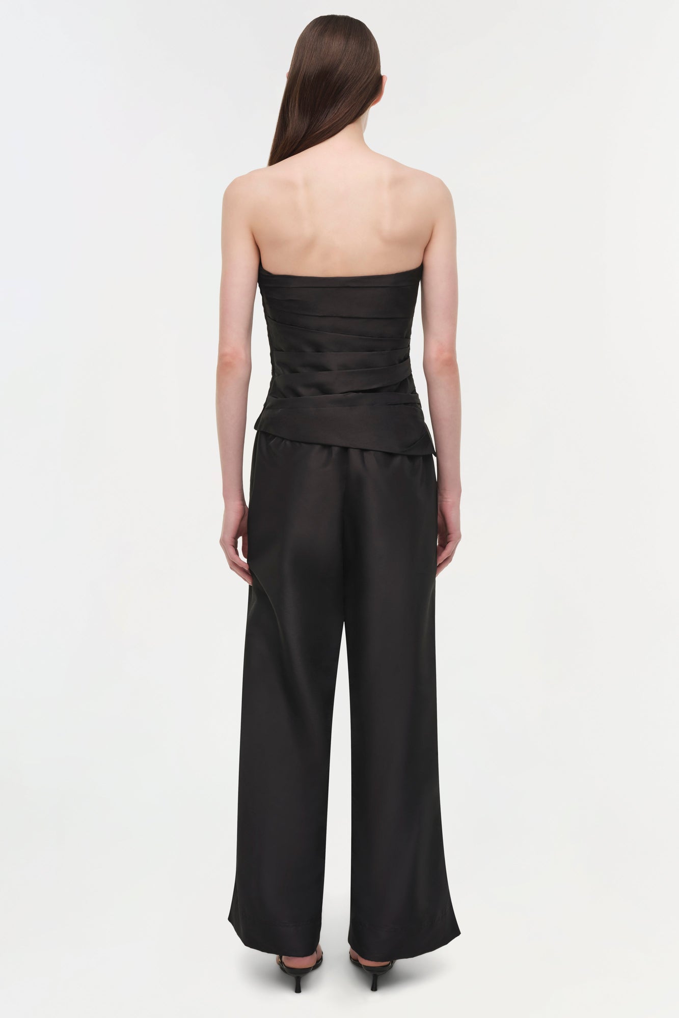 Woman wearing black Arden Taffeta Pull On Pant with strapless top, shown from back view.