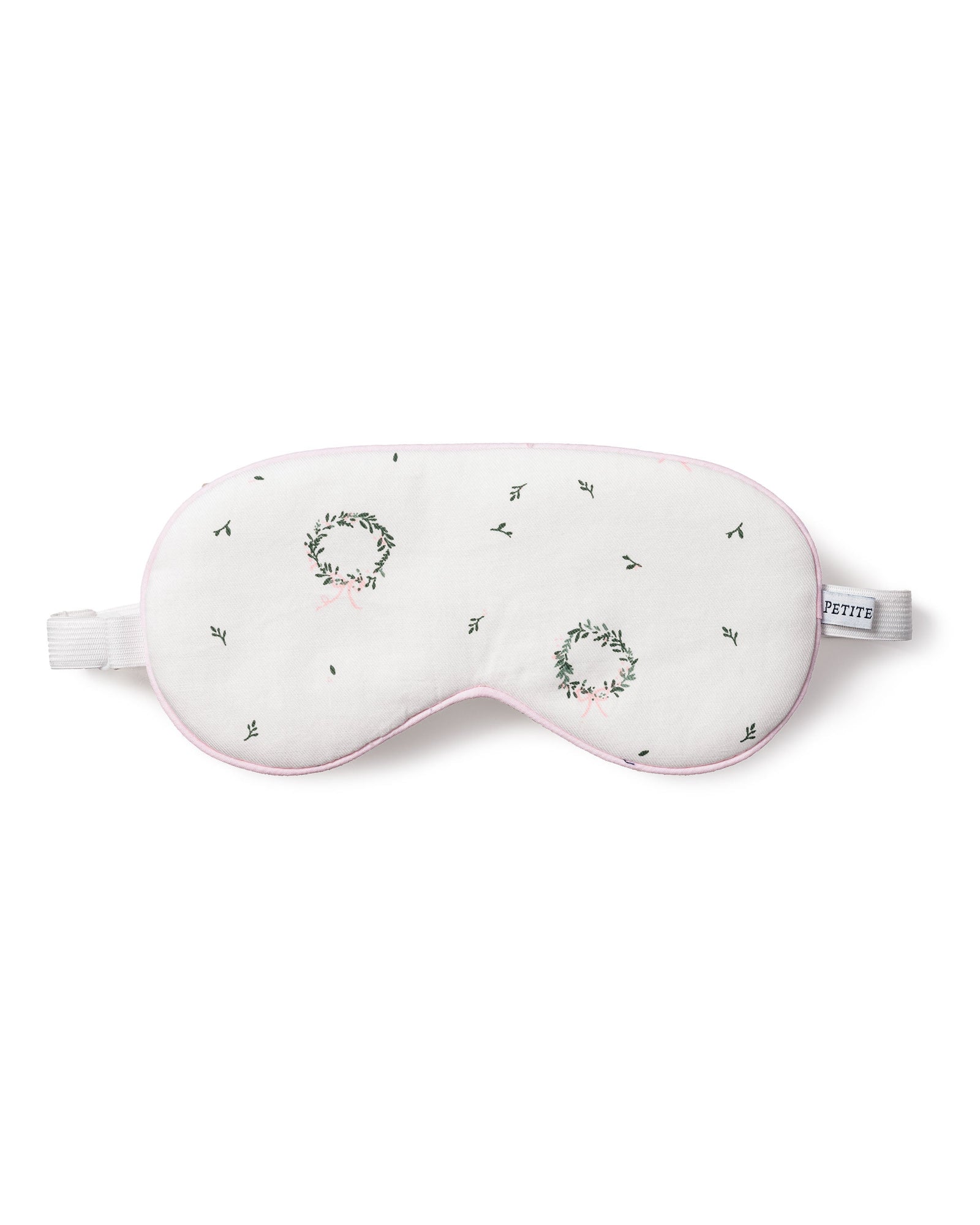 The Petite Plume Adults Twill Sleep Mask in Somerset Wreath features white twill, embroidered green and pink wreaths, black stitching, a white elastic strap, soft pink trim, and a PETITE tag—perfect for matching or gifting.