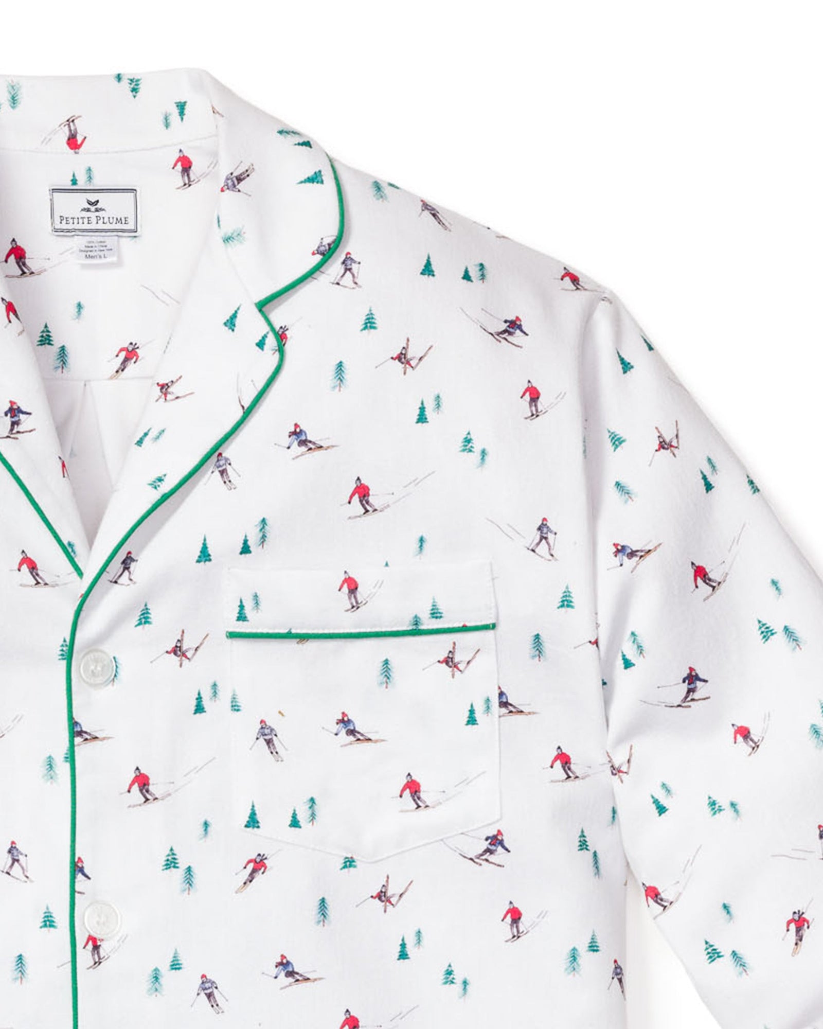 The Mens Flannel Pajama Set in Apres Ski by Petite Plume, crafted from 100% cotton, features small skiers in red and blue amidst tiny green trees. It includes a white top with a front pocket, green piping, and white buttons.