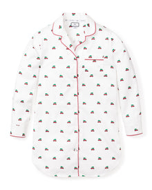 The Womens Twill Nightshirt in Holiday Journey by Petite Plume is a white nightshirt made from 100% cotton twill, with red piping and embroidered small car patterns. It features a button-down front, a single chest pocket, and a curved hem for added charm.