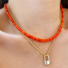 14k yellow gold padlock charm. Styled on a neck locked onto a wheat chain necklace.