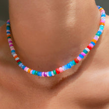 Shimmering beaded necklace made of faceted opals in shades of fiery blues, yellows, red, teal, and purple on a gold linking ovals clasp. 