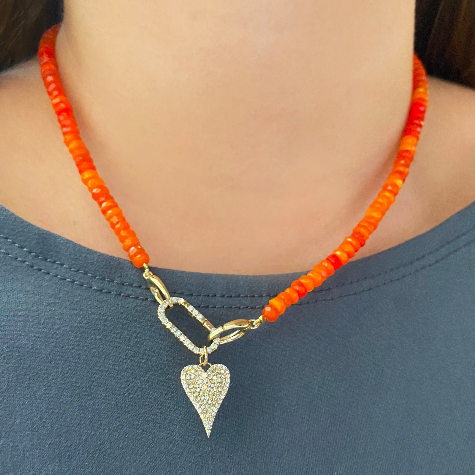 Shimmering beaded necklace made of faceted opals in shades of deep fire orange on a gold linking lobster clasp styled with a Diamond Pavé Face Charm Lock and Medium Pavé Heart Charm