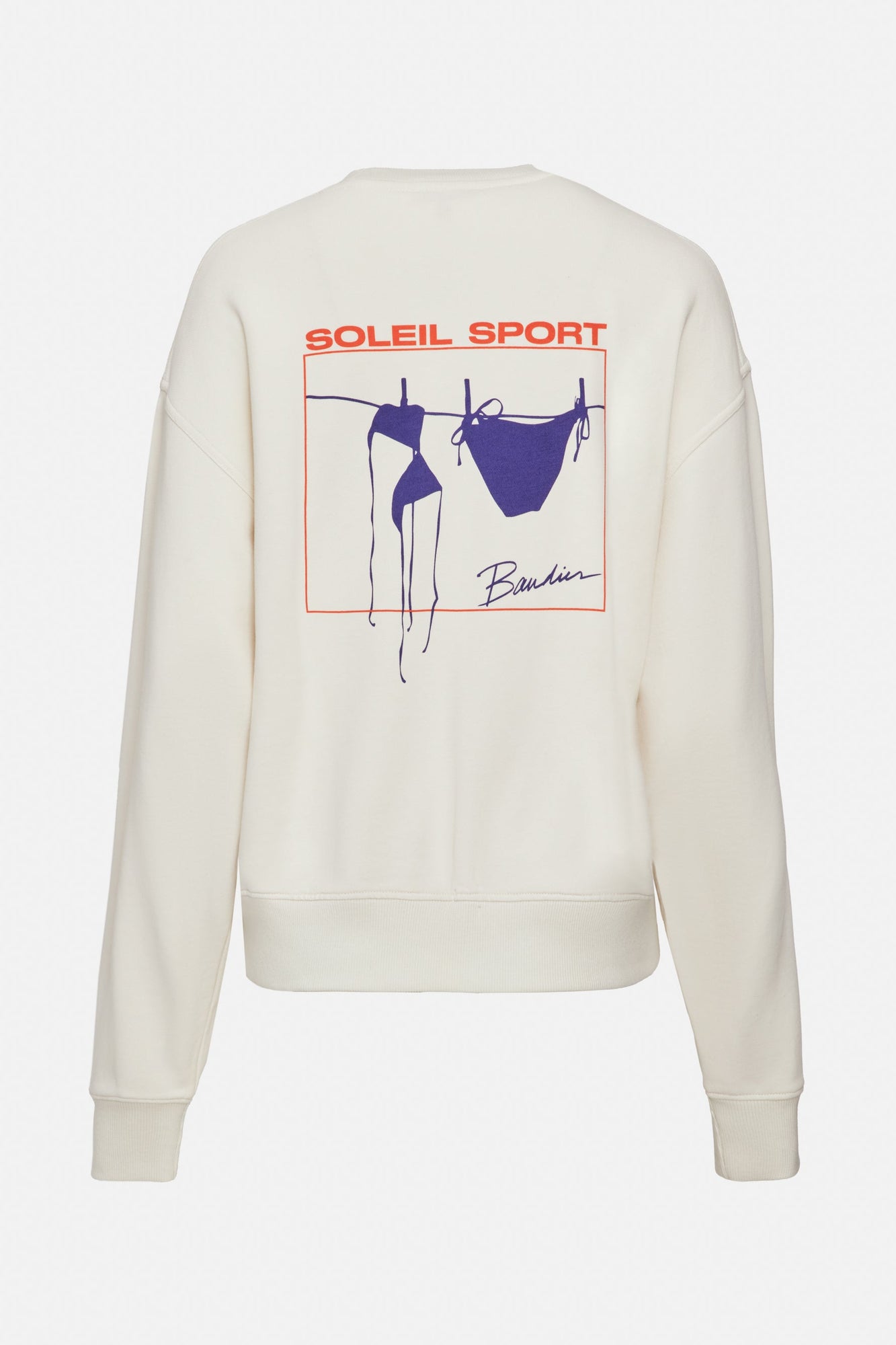 A white crewneck sweatshirt with logo on back that reads "Soleil Sport" and underneath is a square orange border containing a blue bikini hanging to dry on a clothesline. 