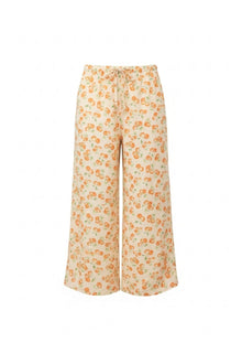 Cream wide-leg pants with orange fruit print and drawstring waist.