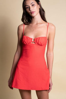 Red slip dress with thin straps and cutout detail at bust, shown on model against neutral background.