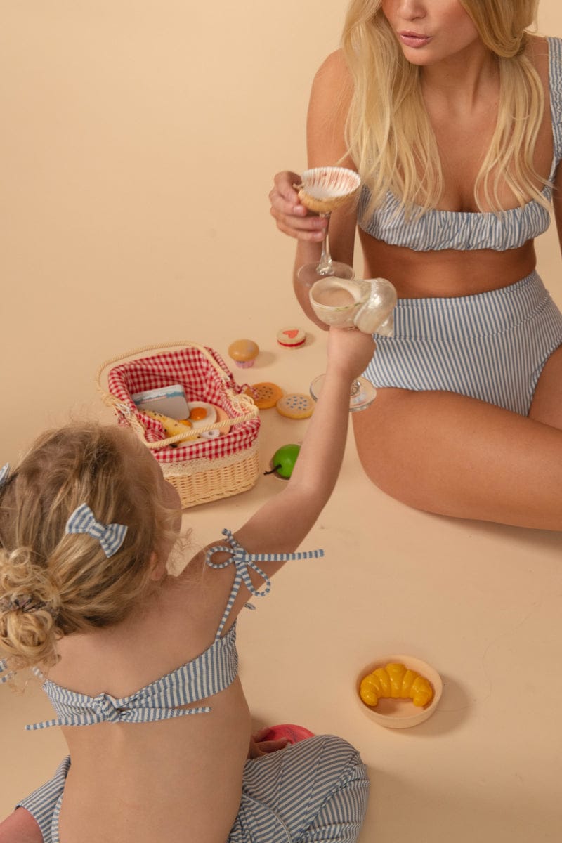 Blue and white striped drawstring shorts with matching bikini top on woman and child.