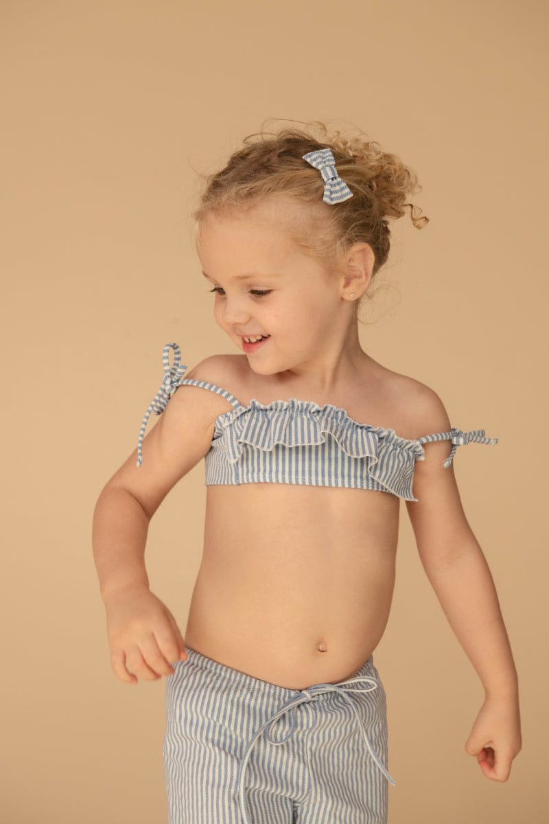 Young child wearing blue and white striped mini drawstring pants with matching bikini top and hair clips.