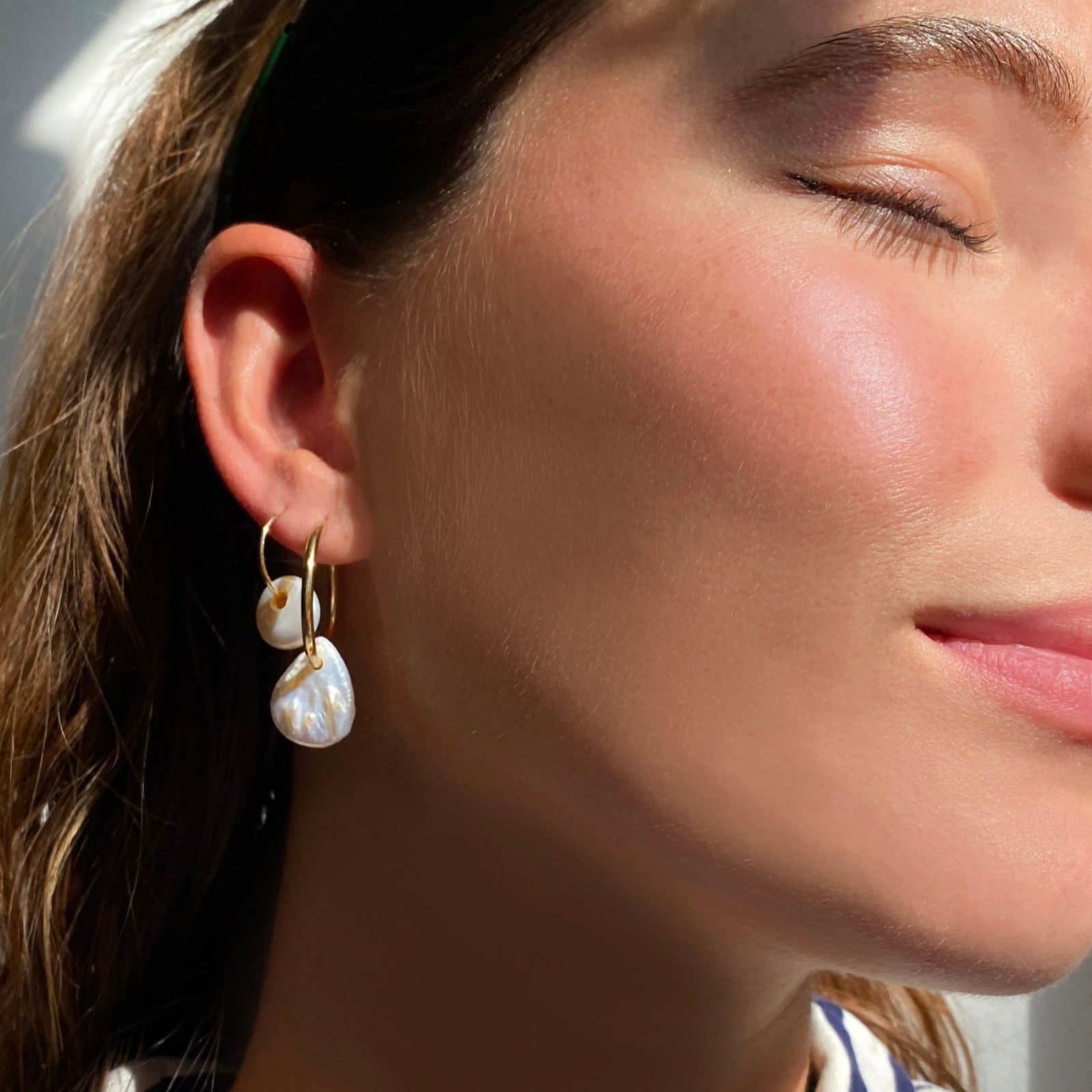 14k gold White Teardrop Coin Pearl Hoops styled on a ear