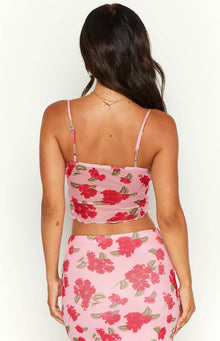 Rear view of a pink mesh cami with red floral print, thin adjustable spaghetti straps, and lettuce-edge hem