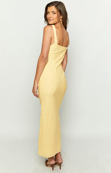 Side view of a yellow broderie anglaise midi dress with a fitted silhouette and straight back neckline
