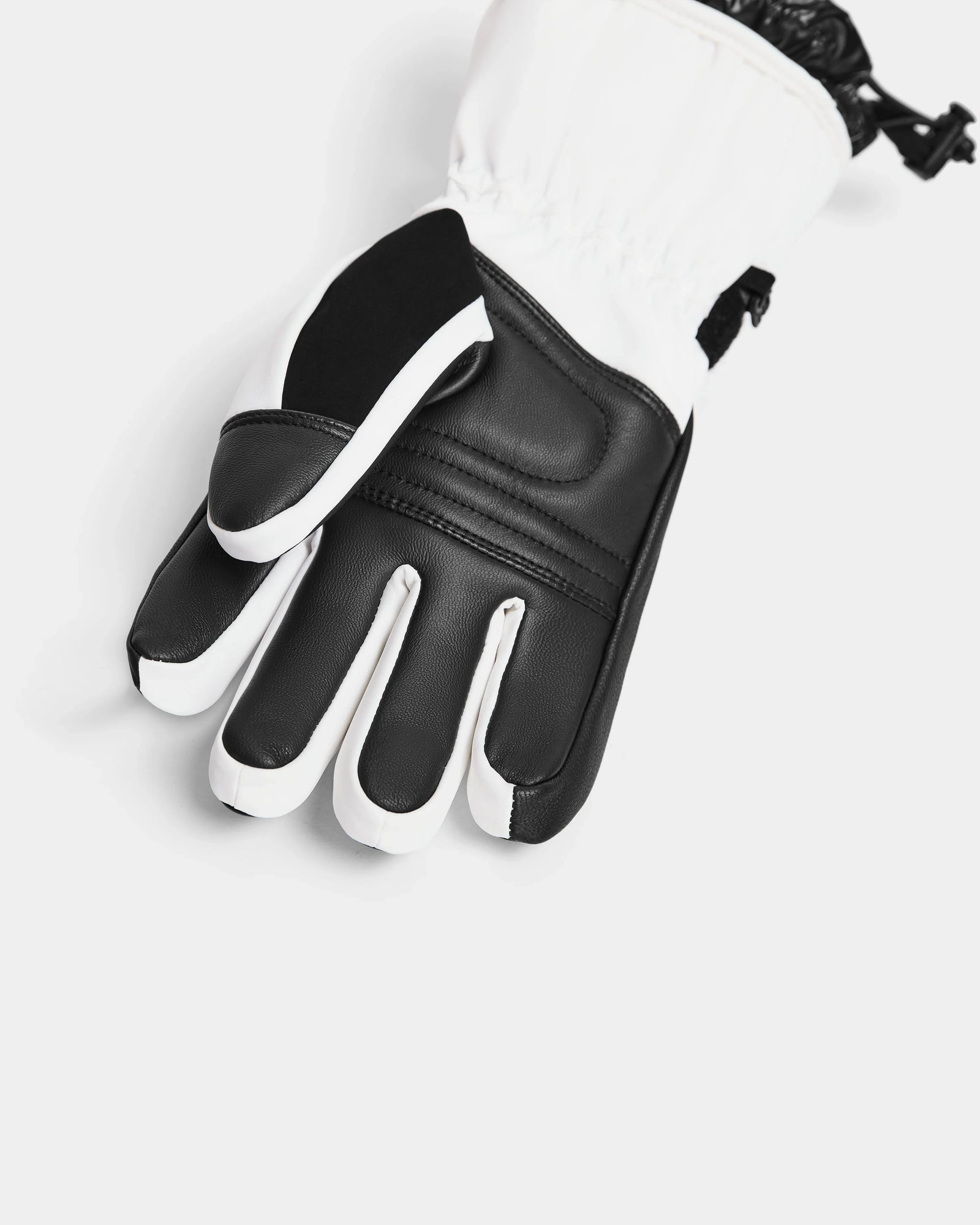 A close-up of the Rudsak APLEN - 6424505 Optic White insulated ski glove featuring reinforced knuckles, a black palm, waterproof zippers, and an adjustable wrist strap, displayed on a white background.
