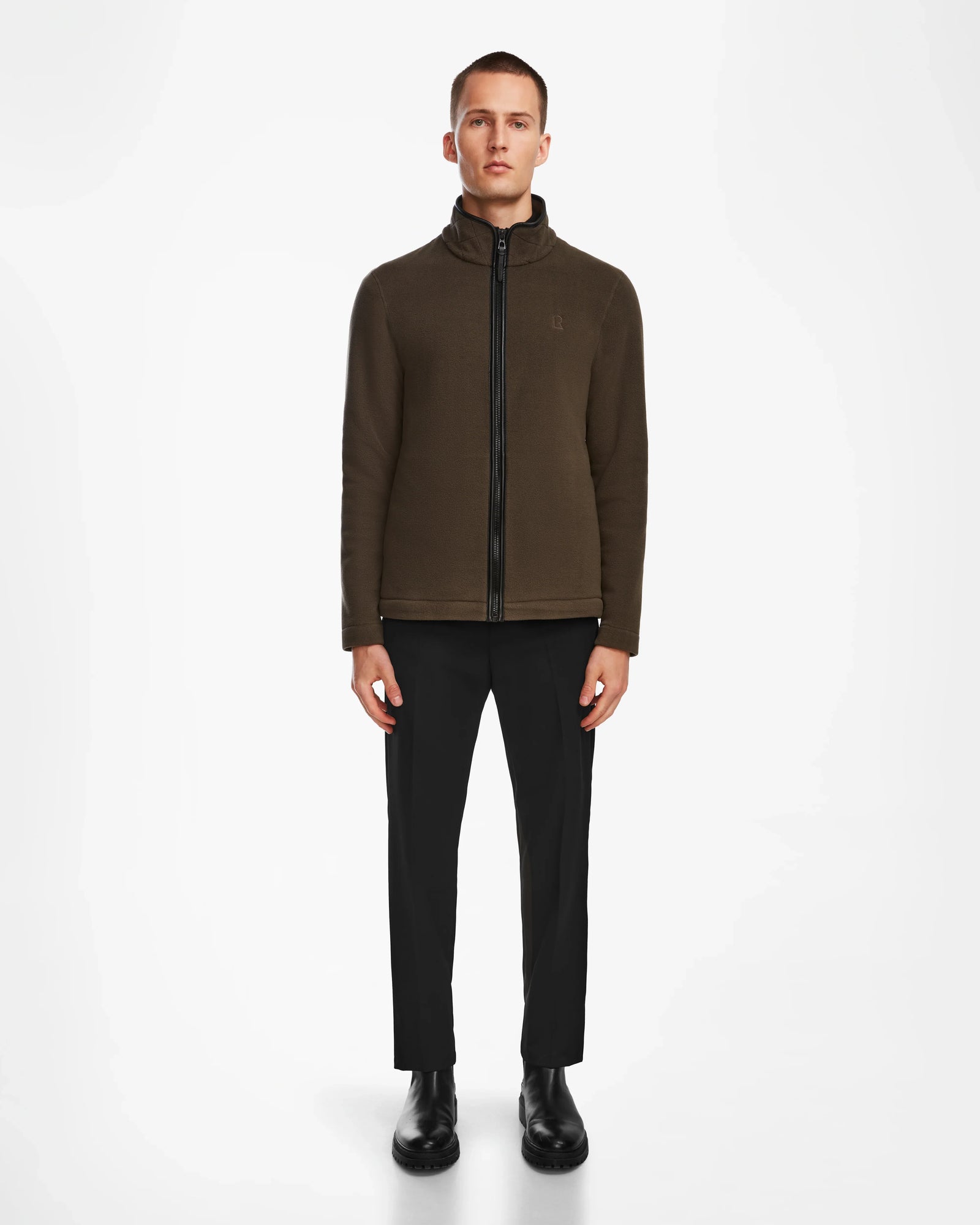 A person faces forward wearing the ARAGON - 6524539 Army fleece full-zip jacket by Rudsak, paired with black pants and shoes, set against a plain white background.