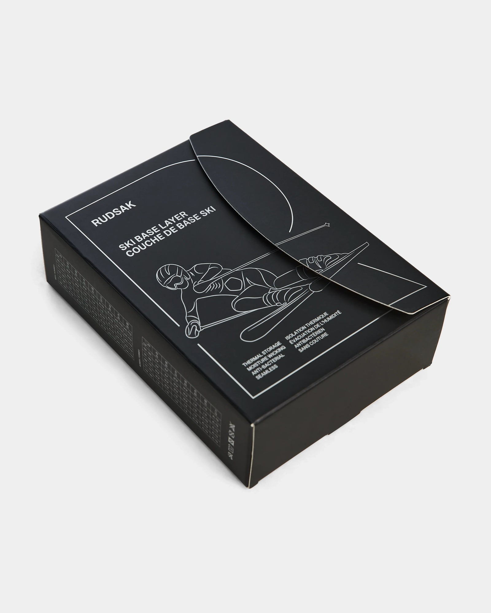 Black rectangular Rudsak box featuring white line art of a skier and “Ski Base Layer” and “Couche de Base Ski”—the perfect packaging for FRANC - 6524541 Iceland, a men’s thermal underwear by Rudsak. Photographed on a white background.