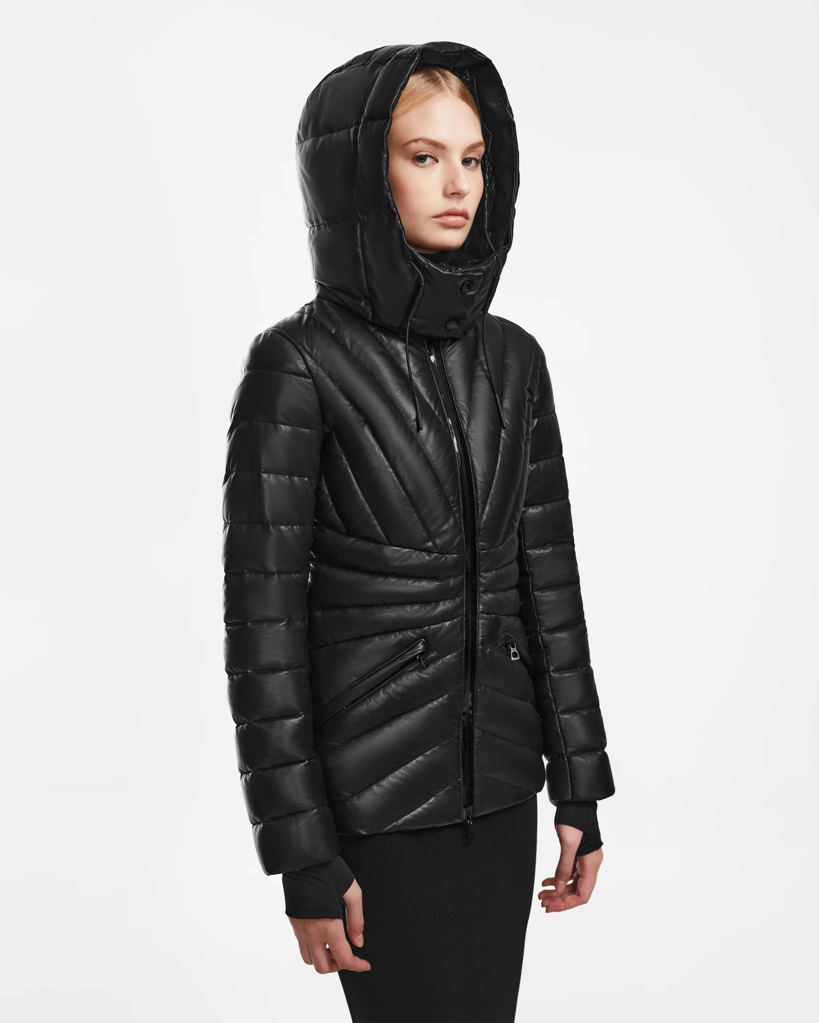 A person wears the Rudsak HANNA X - 8123558 Black shiny hooded puffer jacket with RDS-certified ethical down, standing against a white background and facing slightly to the side with a neutral expression.