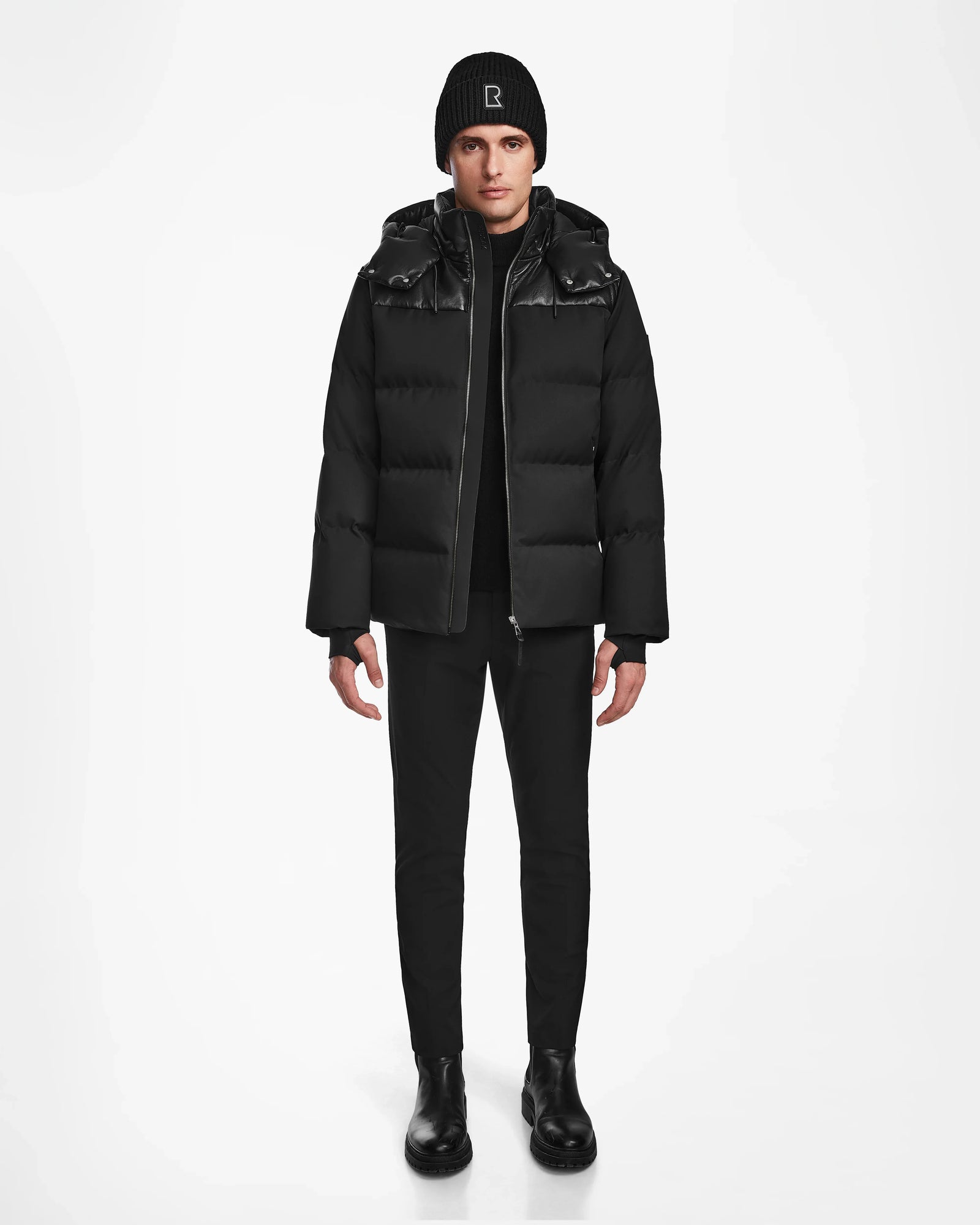 A person stands facing forward wearing the Rudsak JACK - M124507 Black quilted winter jacket on a plain white background.