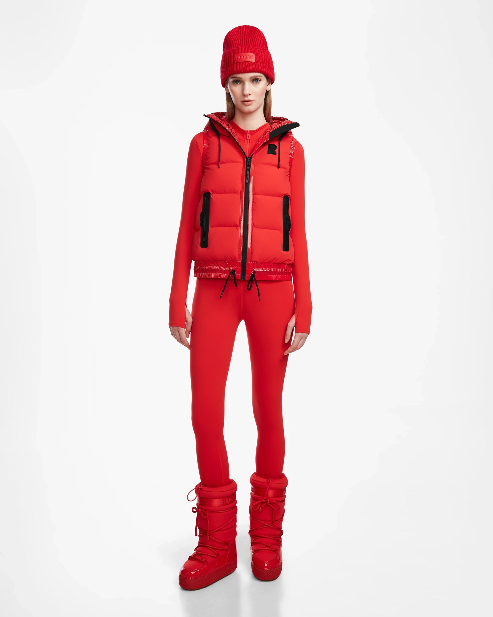 A person wearing the Rudsak RAQUEL M - 8124538 Flame Red stands against a plain white background.