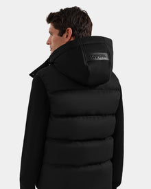A man with short brown hair is seen from the back wearing the Rudsak HARLOW - M125528 Black men’s puffer vest with 
