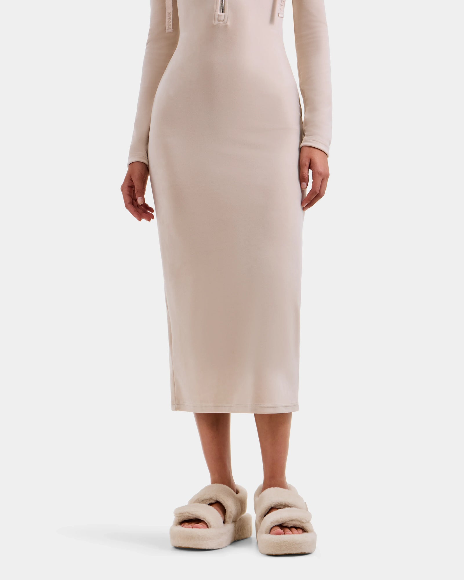 Wearing the Rudsak ISABELLA - L525502 Cream fluffy slip-on sandals, a person in a fitted, long-sleeve women's midi dress stands against a plain white background.