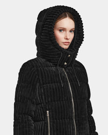A woman wears the MIRRY FF - L124507 Black short down puffer jacket with a large hood and zipper closure, looking slightly to the side against a plain white background.