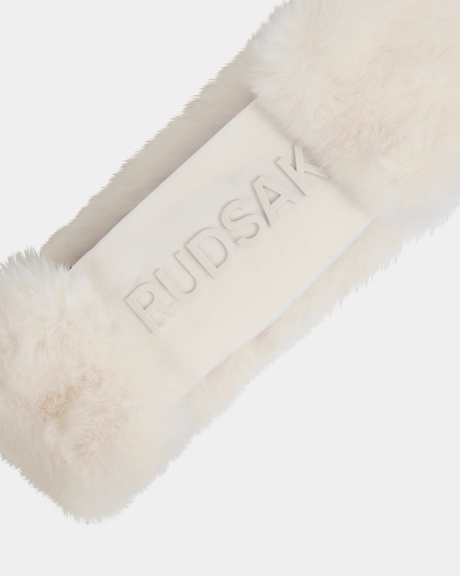 A close-up of the Rudsak SANDIE - L425552 Iceland women’s white faux fur headband, featuring "RUDSAK" embossed on a central fabric panel—an elegant winter accessory.