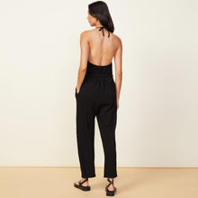 Back view of model wearing the supersoft halter jumpsuit in black.