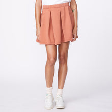 Front view of model wearing the 90's classic tennis skirt in faded rust.