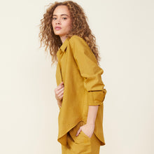 Side view of model wearing the poplin shirt in golden olive.