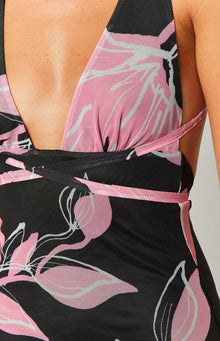 Close-up of the deep V-neckline, ruched bust, and wrap-around waist detail of a black mesh mini dress with pink and white floral print