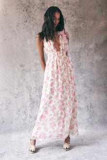 Model wearing pink floral halter maxi dress