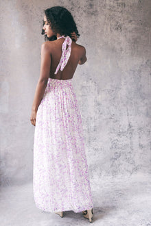 Back image of model wearing white and purple floral halter maxi dress