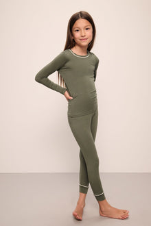 Model wears Kids TENCELâ„¢ Modal Unisex Long PJ Set in moss/ivory.