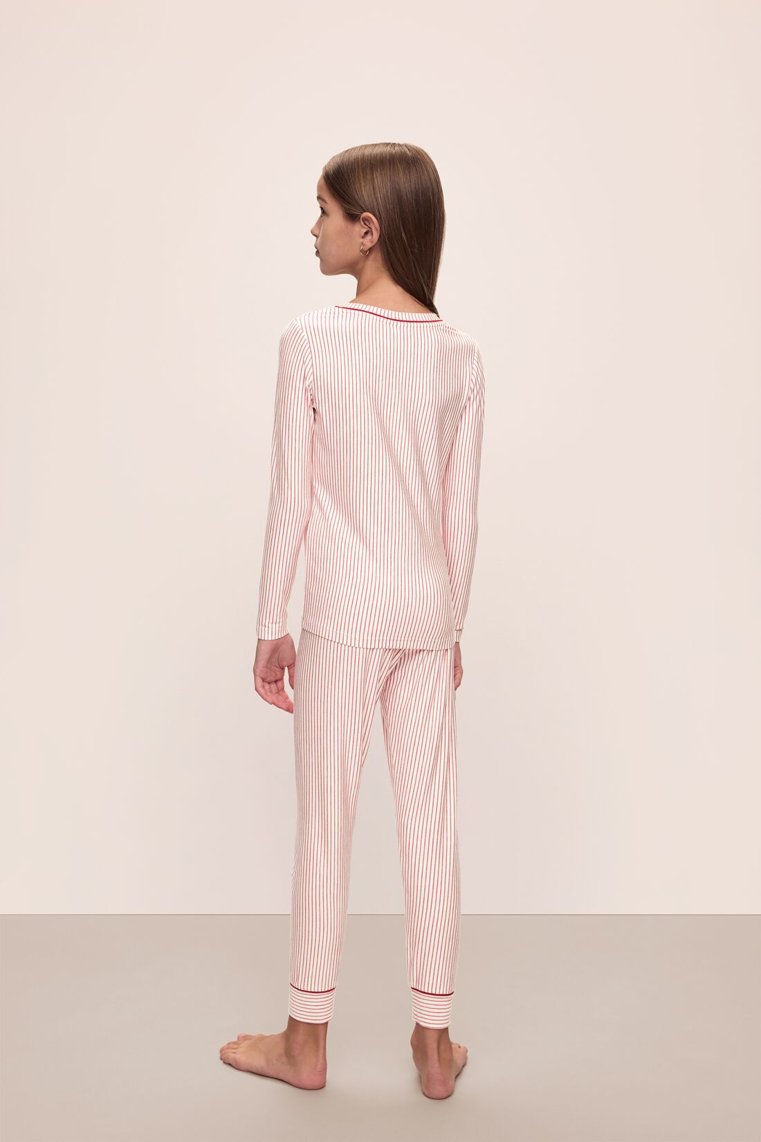 Model wears Kids Printed TENCEL Modal Unisex Long PJ Set in Duo Stripe Haute Red/Haute Red.