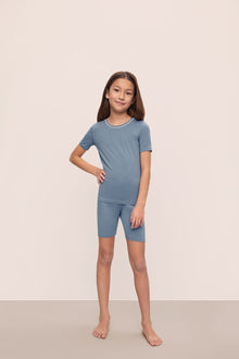 Model is wearing Kids TENCEL Modal Unisex Short PJ Set in Faded Denim/Ivory