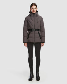 A person stands facing forward in a Rudsak ENZAH - 8124692 Grey down jacket with a black belt, paired with black leggings and ankle boots against a plain white background.