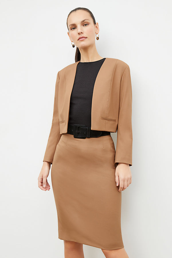 Front image of a woman standing wearing the Neale jacket in camel | Exclude