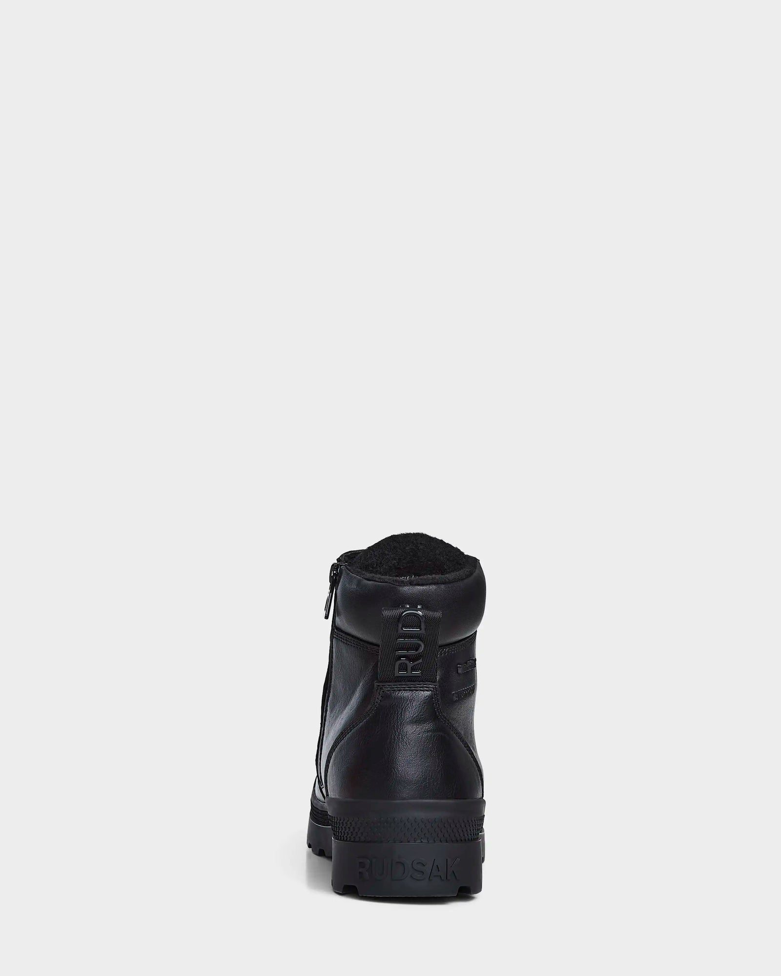 The Rudsak ARTUR - M223501 Black men's ankle boots, crafted from weather-treated leather with a side zipper, pull tab, and RUDSAK embossed heel, are shown from the back against a white background.
