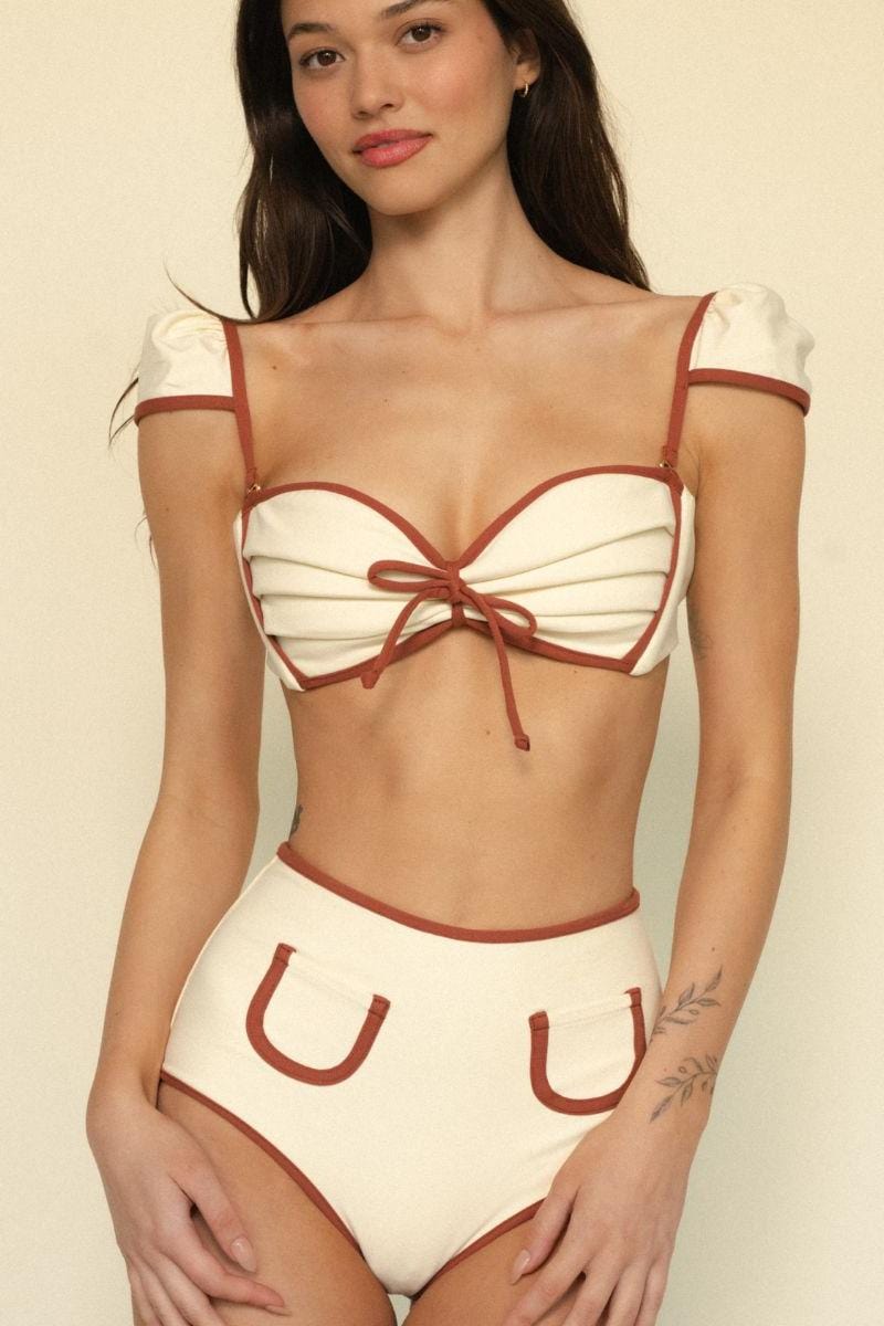 Cream and rust-colored bikini top with bow-tie center detail and puffed off-shoulder sleeves with binding trim.