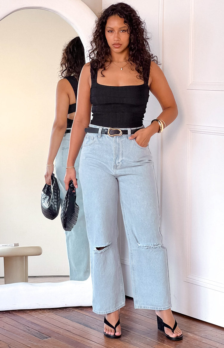 Light blue wide leg denim jeans with distressed rips at the knees