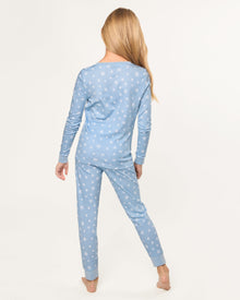 The Kid's Pima Snug Fit Pajama Set in Periwinkle Wonderland features light blue, long-sleeve pajamas with white snowflakes, buttoned neckline, matching elastic waist pants, and cuffed ankles. Shown laid flat on a white background.