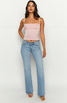 Side view of a pink satin cropped top with thin straps and white trim detail