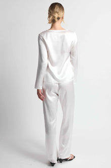 Person wearing a white outfit on a plain background