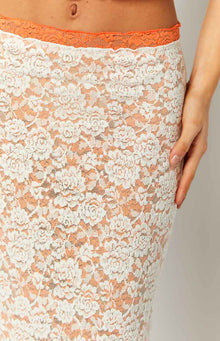 Close-up of the orange lace trim waistband and white floral lace pattern over an orange lining on a midi skirt